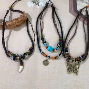 Vintage layered necklace with wooden beads and a large hollow butterfly pendant design
