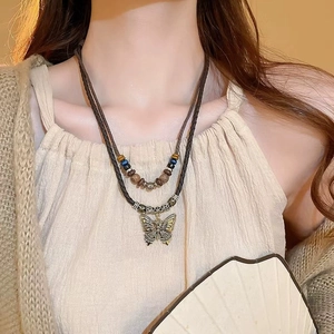 Detail of bohemian double-layer necklace with butterfly pendant and colorful wooden beads