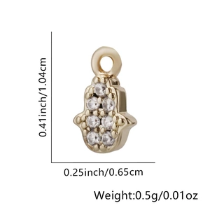Vue macro du pendentif Hamsa en or montrant les mesures de 1,04 cm sur 0,65 cm