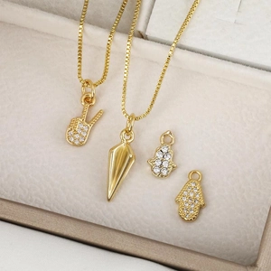 Colliers dorés et pendentifs Hamsa avec zircon blanc dans une boîte à bijoux