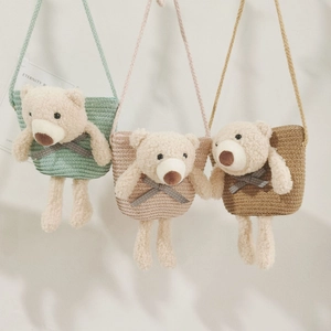 Détail de sacs en paille tissée avec ours en peluche en menthe, rose et marron