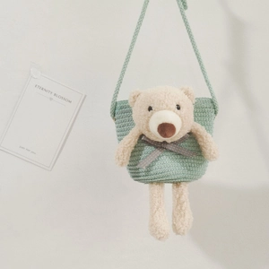 Détail du sac tressé vert clair orné d'un adorable ours en peluche 3D et nœud à carreaux