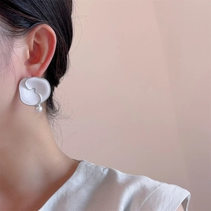 Elegance white enamel flower stud earrings with pearl drop on a model profile