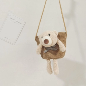 Vue détaillée du sac de plage en paille tressée avec un ours en peluche et une bandoulière