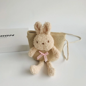Détail du sac en paille pour enfants avec lapin en peluche et nœud en ruban rose