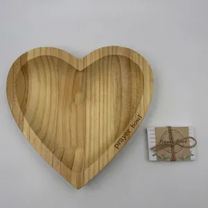Handcrafted heart-shaped wooden prayer bowl with natural wood grain and card tag