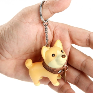 Close-up of a Shiba Inu keychain held by hand showing leather collar and silver ring