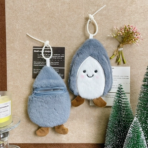 Cute penguin plush coin purse set with zipper and bead chain hanging on a cork board
