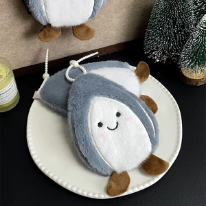 Detail of penguin plush coin purse with bead strap on elegant ceramic tray