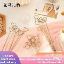 Close-up of golden metal card holders in heart, round, and bear shapes for florist bouquets