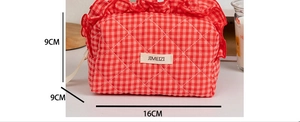 Close-up of red and white checkered makeup bag with ruffled lace and 16x9x9cm dimensions