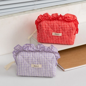 Close-up of quilted cotton makeup bags with ruffles and red or purple checkered patterns