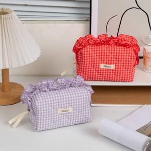 Close-up of quilted cotton cosmetic bags with decorative ruffles and woven labels