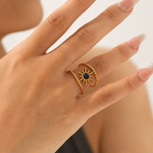 Macro shot of gold sunburst open ring featuring a deep blue lapis lazuli stone inlay