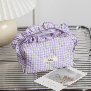 Detail of purple and white checkered quilted makeup bag with lace trim and zipper