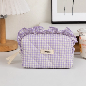 Detailed close-up of quilted lavender checkerboard makeup bag with frill trim details