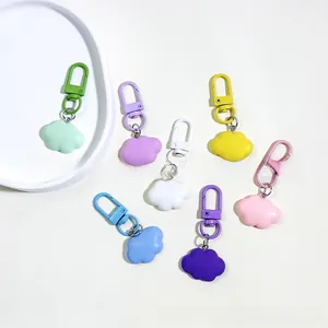 Flat lay of colorful resin cloud keychains in seven pastel shades with metal clasps