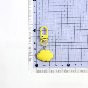 Detail view of yellow resin cloud charm with matching metal lobster clasp on grid board