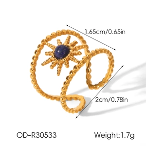 Macro view of gold sunflower ring with blue lapis lazuli and double spiral band