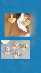 Macro shot of fan-shaped pleated earrings in gold and silver with geometric textures