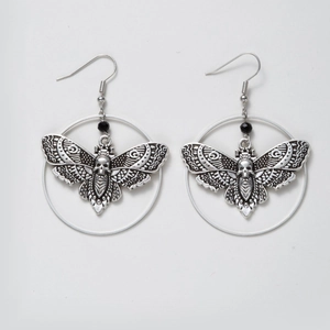 Gothic silver moth hoop earrings with skull pattern and black bead on gray background