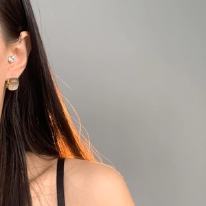 Eleganti orecchini a perno quadrati dorati con zirconi indossati per un look raffinato