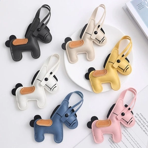 Close-up of luxury pony leather charms with hand-stitched details and matching straps