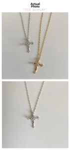 Close-up of gold and silver cross necklaces featuring delicate diamond pavé detailing