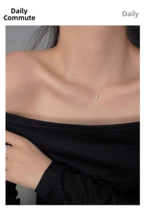 Detail of 14K gold plated silver cross necklace worn by model on neck and collarbone