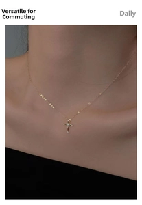 Close-up of elegant 14K gold plated cross pendant necklace with white zircons on female neck