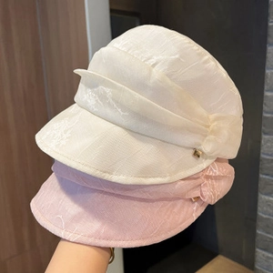 Close-up of textured summer hats in beige and pink with stylish folded side details