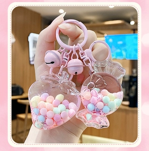 Close-up of pink strawberry and candy keychains with macaron beads and small bells