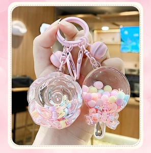 Detail of pink keychain featuring rose charm and snow globe with macaron beads