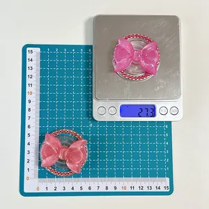 Glittery pink bow Magsafe grip weight 27.3g and diameter 5.5cm shown on scale