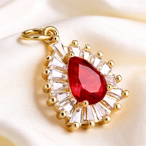 Macro view of teardrop red ruby pendant with baguette-cut stones on silk background