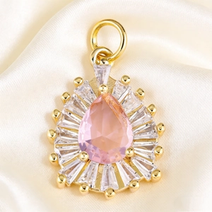 Close-up of pink teardrop crystal pendant with radial zircon setting on silk fabric