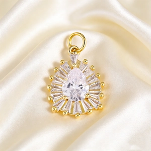 Macro view of pear-shaped crystal pendant on champagne silk with sunburst diamond setting