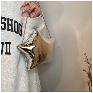 Close-up of a silver star-shaped metallic crossbody bag with chain strap and shiny finish