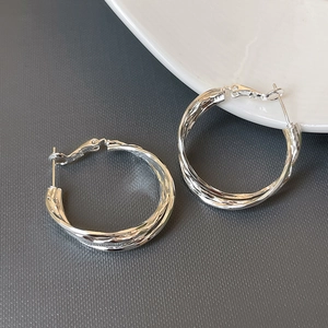 Silver multi-layer twisted hoop earrings with a modern minimalist mirror finish style