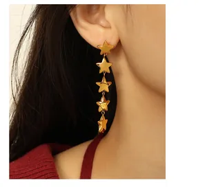 Détail des boucles d'oreilles étoiles en or 18 carats portées avec finition polie