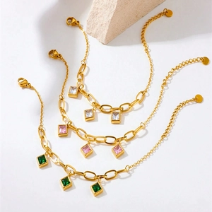 Detailed set of three gold chains featuring square zircon charms and paperclip links