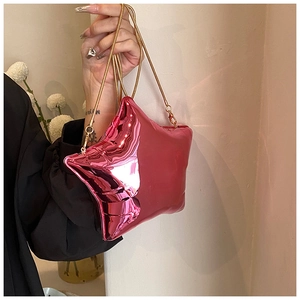Detail shot of mini star-shaped acrylic clutch bag in glossy pink with golden chain strap
