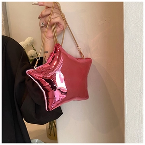 Detailed macro view of the bright pink star-shaped bag with golden chain strap