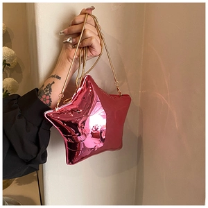 Detail view of the shiny metallic pink star shaped mini bag with golden chain strap