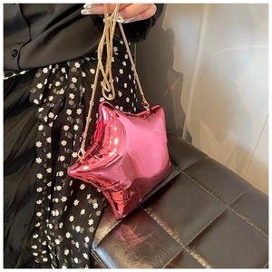 Detail of hot pink star-shaped acrylic mini bag with golden chain and metallic finish