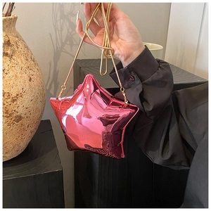 Close-up of a pink star-shaped acrylic mini clutch with gold chain and mirror finish