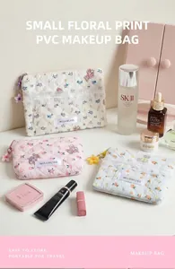 Dettaglio della borsa cosmetica in PVC trapuntato a fiori con ciondolo a forma di fiore