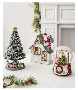 Close-up of resin mini Christmas tree, glowing Santa house, and crystal snow globe set