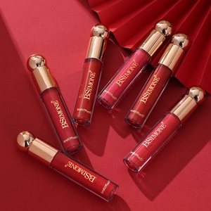 Set of six matte liquid lipsticks in gold-capped tubes arranged on red fan background