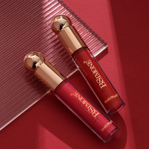 Detail view of red liquid lipsticks with premium gold spherical caps and glass texture
